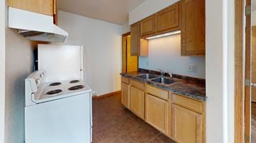 La Crosse apartment for rent - A kitchen with a white stove and wooden cabinets.