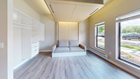 La Crosse apartment for rent - A spacious room with a white couch and a window overlooking a parking lot.