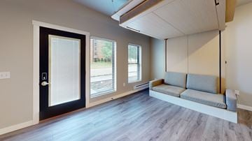 La Crosse apartment for rent - A modern living room with a grey sofa and a black door.