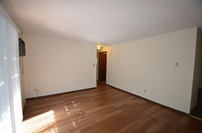 La Crosse apartment for rent - A room with wooden flooring and a door in the background.