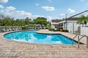 Pompano Beach apartment for rent - A swimming pool surrounded by a brick patio and a white fence.