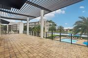 Miramar apartment for rent - A patio with a pool and a building in the background.