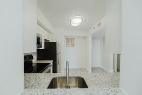 Brickell apartment for rent - A kitchen with a sink and a refrigerator.
