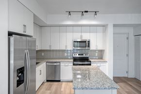 Tamarac apartment for rent - a kitchen with white cabinets and a granite counter top
