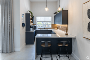 Hollywood apartment for rent - a kitchen with black cabinets and a counter top and two stools