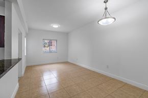 Hialeah apartment for rent - A room with a window and a hanging light fixture.