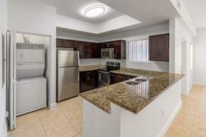 Hialeah apartment for rent - A kitchen with granite countertops and stainless steel appliances.