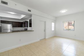 Hialeah apartment for rent - A spacious room with a kitchen area and a window.