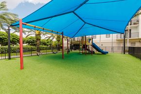 Hialeah apartment for rent - A playground with a blue canopy and a yellow slide.