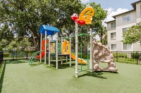 Davie apartment for rent - A playground with a slide, climbing frame, and a swing set.