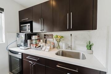 Miami apartment for rent - A kitchen with brown cabinets and a white countertop.