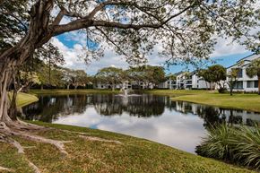 Coconut Creek apartment for rent - A serene park with a pond, trees, and a fountain.