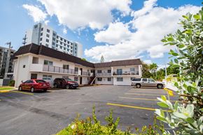 Miami apartment for rent - A parking lot with cars and a building in the background.