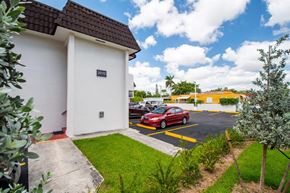 Miami apartment for rent - A red car is parked in a yellow-striped parking space.