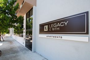 Miami apartment for rent - a sign for legacy apartments on the side of a building