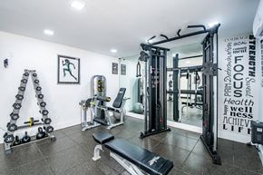 Pinecrest apartment for rent - A gym with a variety of equipment including weights and a bench.