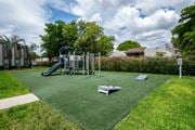 Kendall apartment for rent - A playground with a green slide and a seesaw.