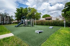 Kendall apartment for rent - A playground with a green slide and a seesaw.