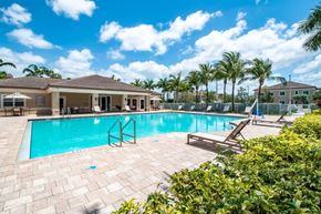 Hialeah Gardens apartment for rent - a swimming pool with palm trees and a house in the background