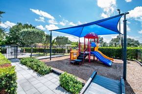 Davie apartment for rent - A playground with a red and yellow slide and a blue canopy.