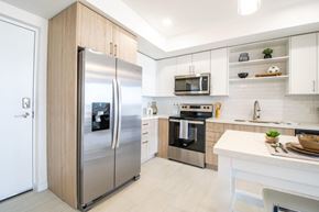 Miami apartment for rent - a modern kitchen with stainless steel appliances and white cabinets