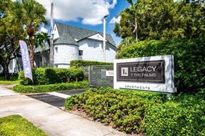 Kendall apartment for rent - A sign for Legacy at the Palms Apartments is in front of a building.