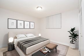 Hialeah apartment for rent - an image of a bedroom with a bed and a plant