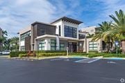 Miramar apartment for rent - A modern building with a parking lot in front.