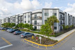 Tamarac apartment for rent - A parking lot with cars and apartment buildings in the background.