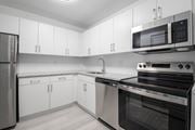 Kendall apartment for rent - A modern kitchen with white cabinets and stainless steel appliances.