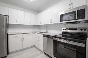 Kendall apartment for rent - A modern kitchen with white cabinets and stainless steel appliances.