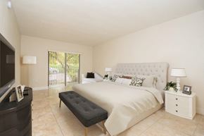 Kendall apartment for rent - the master bedroom has a large bed and a tv