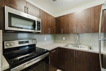 Hialeah apartment for rent - A kitchen with a stove, microwave, and refrigerator.