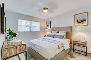 Miami apartment for rent - A bedroom with a large bed and a painting on the wall.