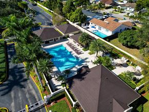 Miami apartment for rent - A swimming pool surrounded by palm trees and houses.