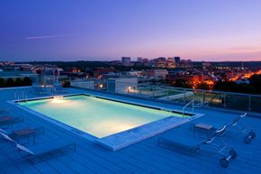 Washington apartment for rent - a pool on the roof of a building overlooking a city at night