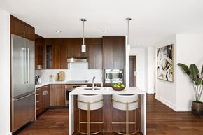 Washington apartment for rent - a modern kitchen with wooden cabinets and a white island with three stools