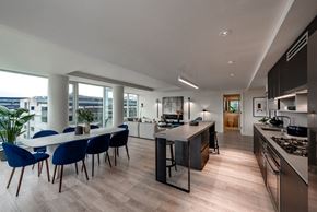 Washington apartment for rent - an open kitchen and dining area with a large table and chairs and a large window