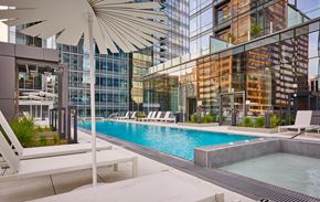 Arlington apartment for rent - A pool area with a white umbrella and lounge chairs.