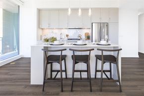 Bethesda apartment for rent - a kitchen with white cabinets and a counter top with three stools
