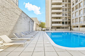 Arlington apartment for rent - A pool surrounded by sun loungers and a brick wall.