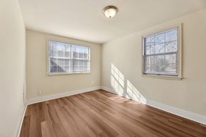 Falls Church townhouse for rent - A room with wooden floors and two windows.