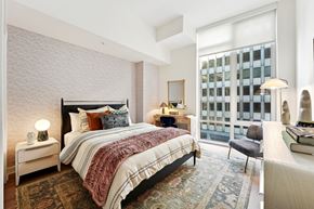 Arlington apartment for rent - A bedroom with a large bed and a window overlooking a building.