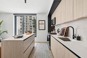 Arlington apartment for rent - A modern kitchen with wooden cabinets and a large window.