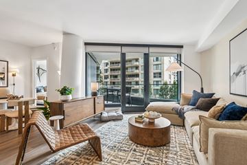 Arlington apartment for rent - A modern living room with a wooden chair and a large window.