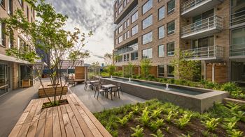 Courtyard with lush landscaping, fire bowl, fountain and built-in bench seating