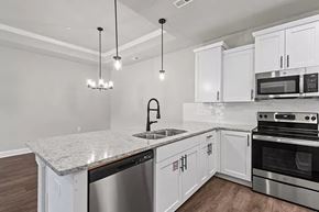 Huntsville apartment for rent - A modern kitchen with white cabinets and stainless steel appliances. at The Villas at Nature Walk, Huntsville, AL, 35824