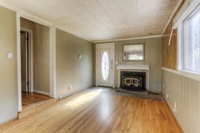 Denver apartment for rent - an empty living room with a fireplace and wooden floors