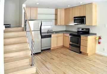 Denver apartment for rent - A kitchen with wooden cabinets and a staircase.