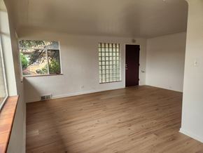 Denver apartment for rent - A room with wooden flooring and a window with a view of trees.